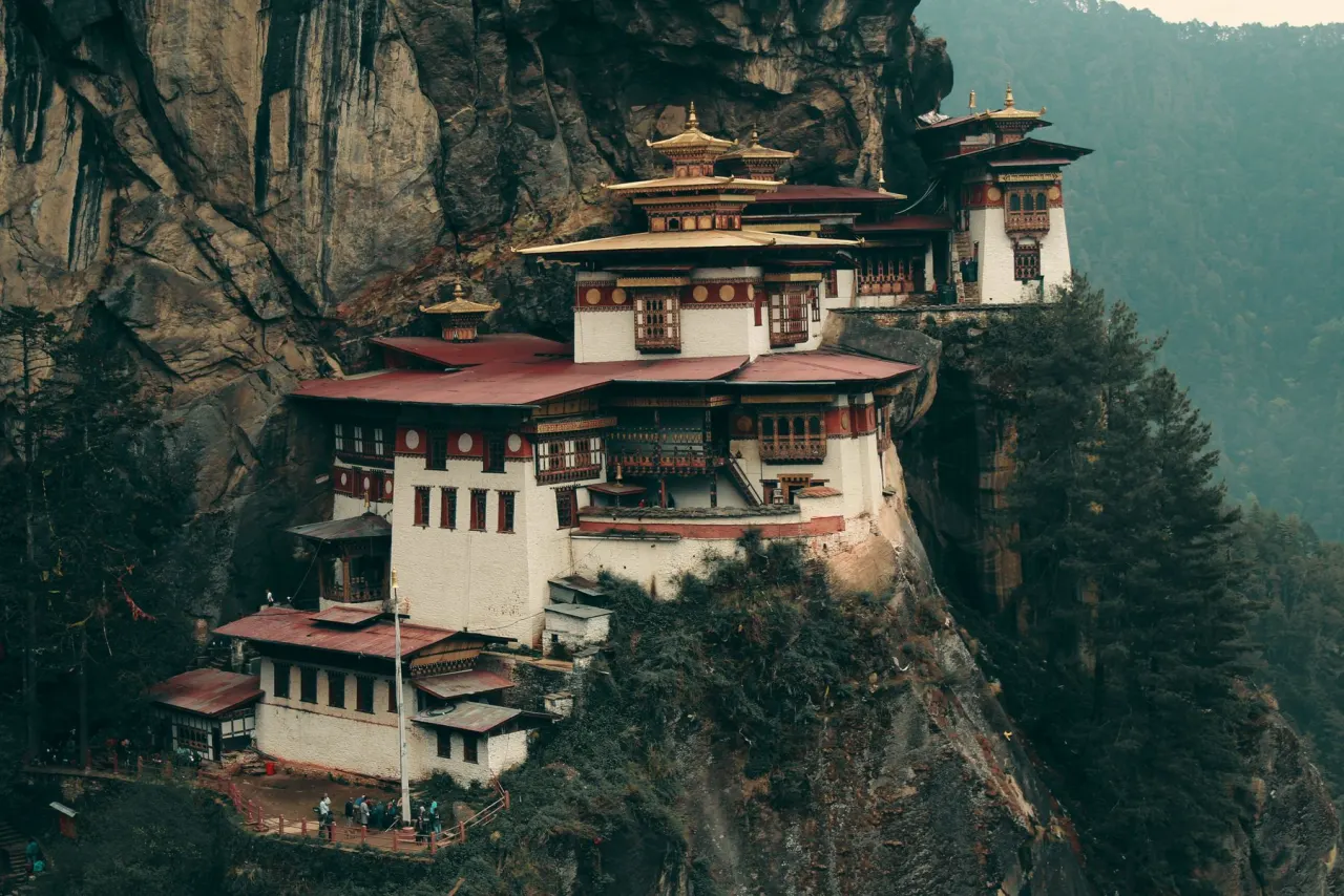 Paro Taktsang monastery built into a forested cliff in Bhutan