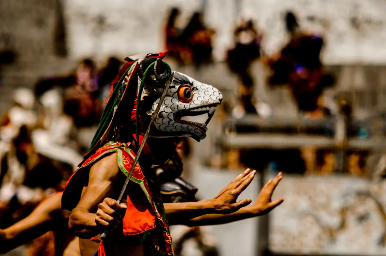A masked dancer performing at a Bhutanese festival