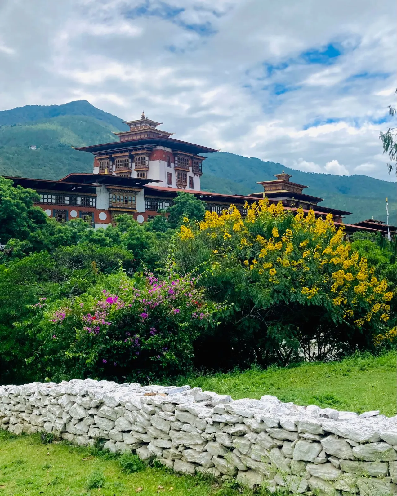 A Bhutanese dzong surrounded by green mountains and river valleys